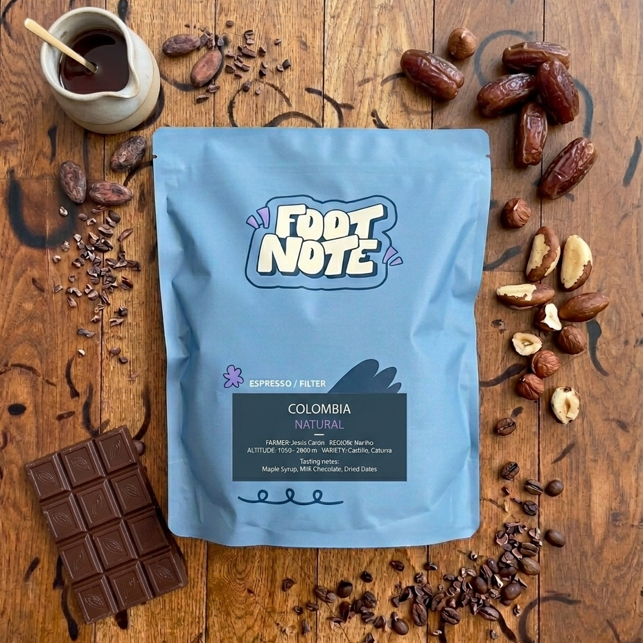 Foot Note coffee package on a wooden surface with coffee beans, chocolate, and dates.